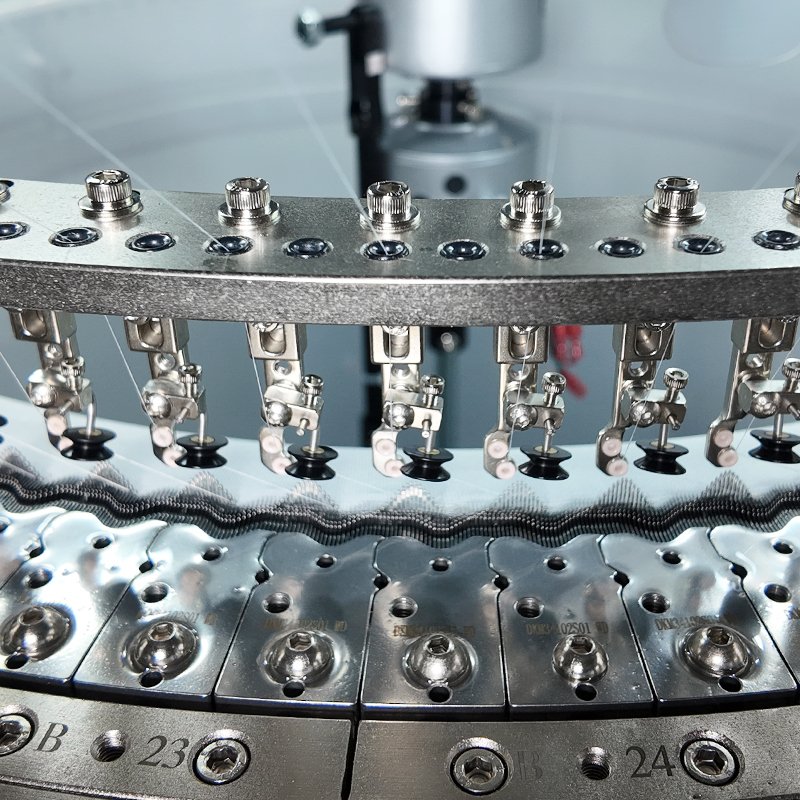 Precision yarn carriers and ceramic thread guides on 24G single jersey circular knitting machine cylinder